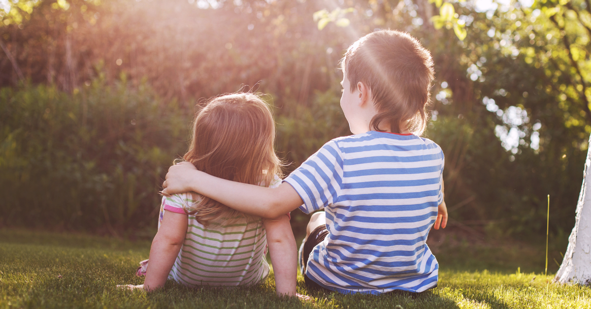 Kuntoutus- ja terapiapalvelut kuvituskuva, kaksi lasta istumassa nurmikolla